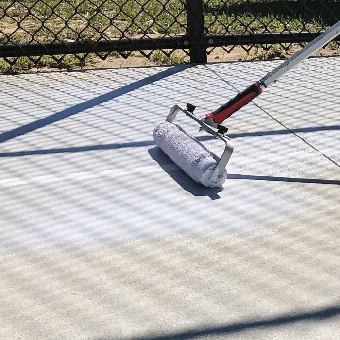 Mapei Mapecoat TNS Primer EPW being rolled on to a tennis court